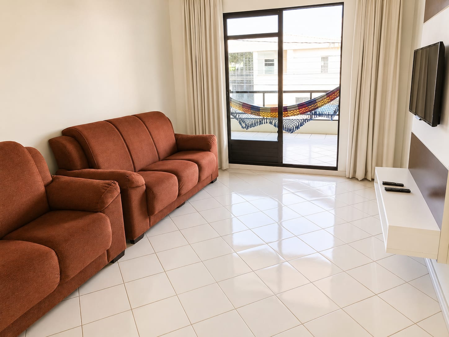 Sala de estar com TV e saída para a sacada